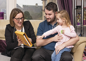 father and young daughter with healthcare worker