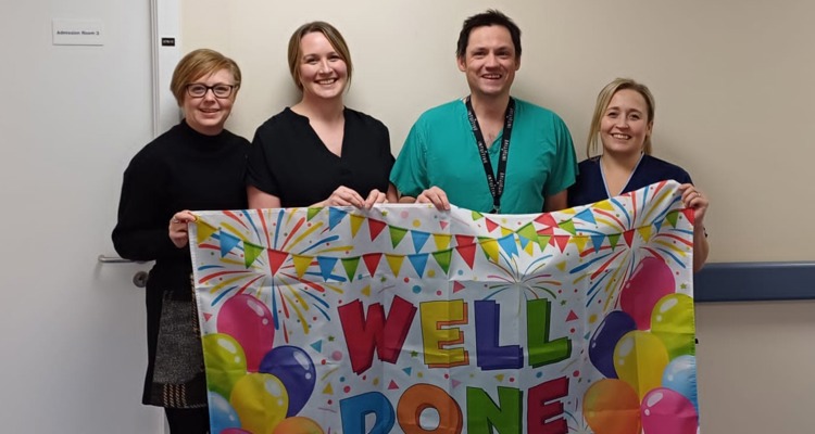 endoscopy unit staff with 'well done' banner