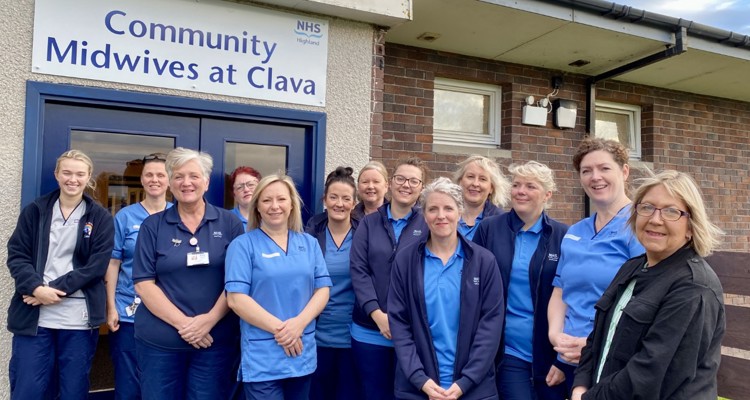 The NHS Highland Community Midwife team outside of the Clava building under a sign that says 